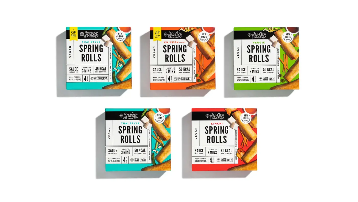 A group of Lucky Foods spring roll packages arranged on a tabletop for ecommerce catalog photography.