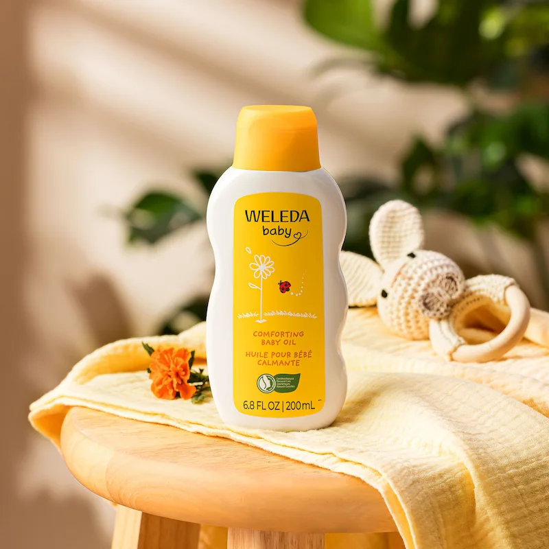 Lifestyle product photography of Weleda body oil in a natural, aspirational environment